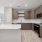 Photo of Aventon Soraya's kitchens with brown slab cabinets, white quartz countertops and subway tile backsplash